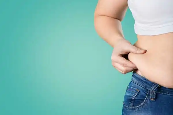 Image of woman pinching her love handles to show weight gain Westwood